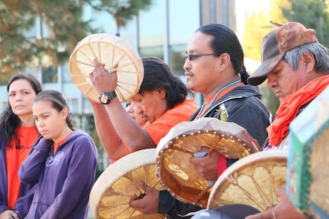 man playing ceremonial drum during Indigenous reconciliation event