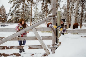 Two female students working on ranch in snow