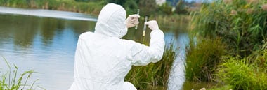 Student taking specimen sample in pond