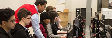 teacher helping student on computer