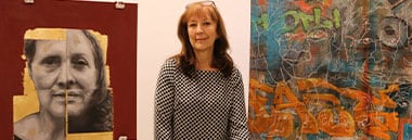 student sitting between two paintings