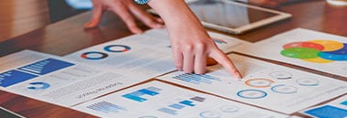 Several people looking at graphs on paper on desk